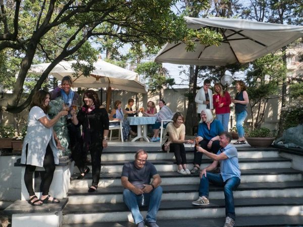 Tableau of Chiavari retreat writers positioned on hotel terrace steps