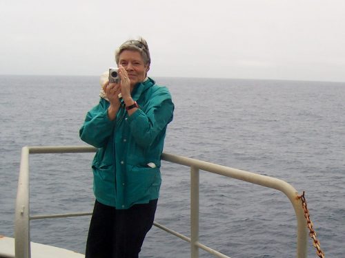 A photo of writer Sandra Shaw Homer with camera onboard a ship